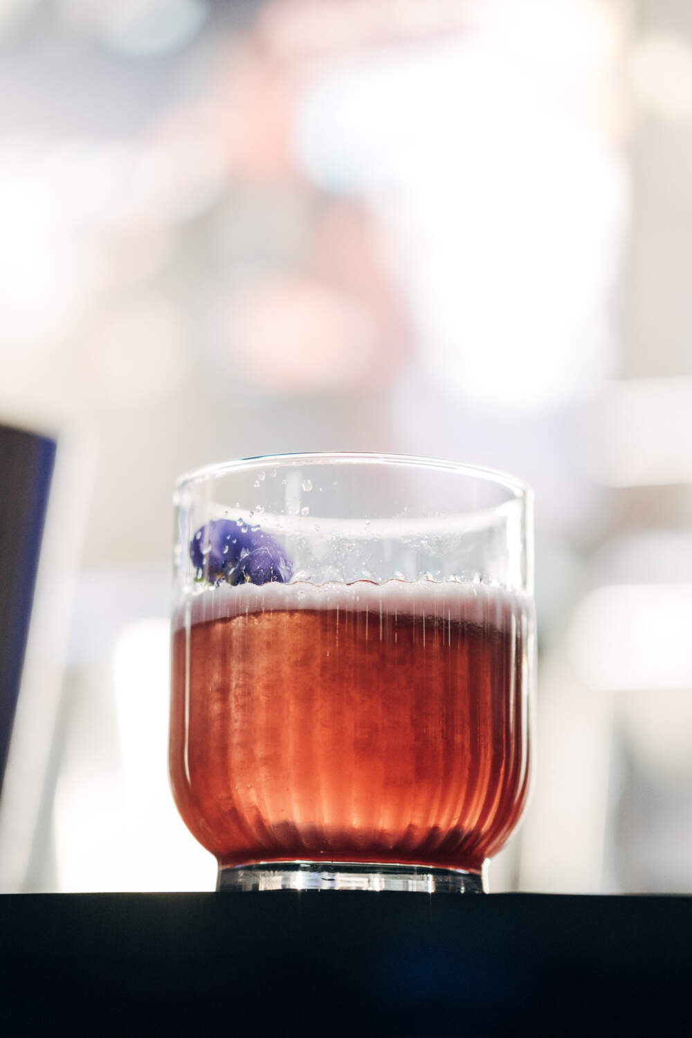 Cocktail TAG Heuer à base de vodka infusée aux baies roses, sirop d'hibiscus, verjus, jus de framboise et basilic